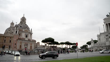 Die-Kirche-Santa-Maria-Di-Loreto-Wird-Von-Der-Piazza-Venezia-Neben-Dem-Denkmal-Von-Vittorio-Emanuele-II.-In-Rom-Mit-Vorbeiströmendem-Verkehr-Gesehen