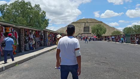Langsame-Schwenkaufnahme-Von-Touristen,-Die-An-Ständen-Einkaufen-Und-Auf-Die-Pyramide-Von-Teotihuacan-Zulaufen