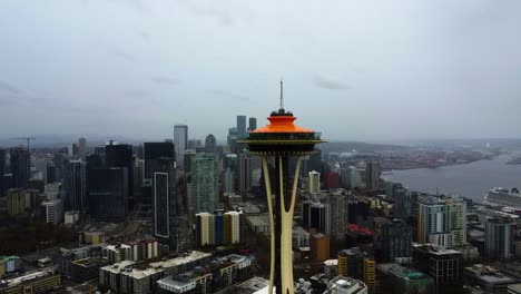 Aerial-view-circling-toward-the-Space-Needle,-in-cloudy-Seattle-city,-WA,-USA