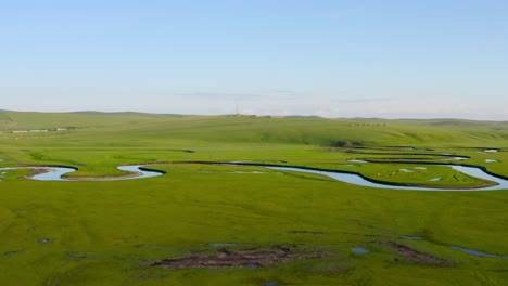 Drone-pulls-back-away-from-meandering-river-on-mongolian-grassland-plains