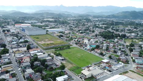 Football-field-in-the-Favelas-of-Rio-de-Janeiro-with-some-female-players---distant-aerial-drone-shot