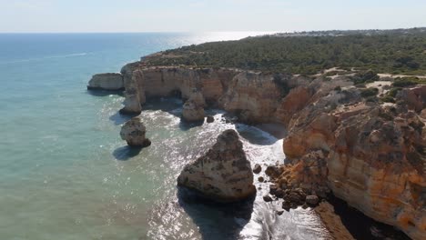 Panoramic-aerial-wide-view-of-Praia-da-Marinha,-seagulls-soar-above-coastline,-Algarve-Portugal