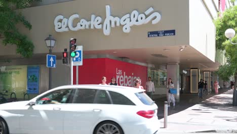 Los-Peatones-Esperan-En-Un-Semáforo-Frente-A-Los-Grandes-Almacenes-Más-Grandes-De-España,-El-Corte-Inglés,-Y-El-Logotipo-Visto-En-España.