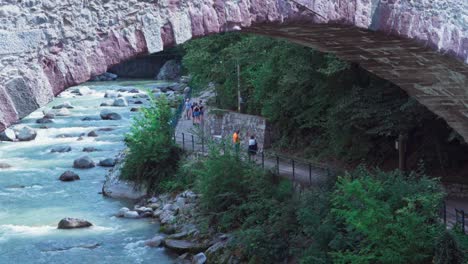 La-Gente-Disfruta-De-Un-Agradable-Día-Caminando-Por-El-Paseo-Marítimo-Justo-Debajo-Del-Famoso-Puente-De-Piedra.