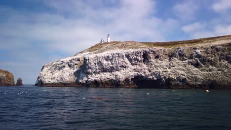 Wide-gimbal-shot-from-a-moving-boat-of-the-Anacapa-Island-Lighthouse-on-East-Anacapa-Island,-part-of-Channel-Islands-National-Park-in-the-Pacific-Ocean