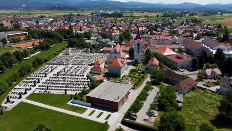 Aerial-flyover-church-with-cemetery-in-small-Slovenian-village-during-sunny-day