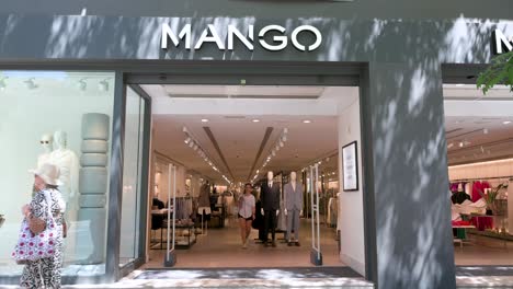 Los-Peatones-Pasan-Por-La-Tienda-De-Mango-De-La-Marca-De-Ropa-Multinacional-Española-Mientras-Los-Compradores-Salen-De-La-Tienda-En-España