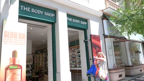 Pedestrians-and-shoppers-walk-past-the-British-cosmetics,-skincare,-and-perfume-company,-The-Body-Shop-in-Spain