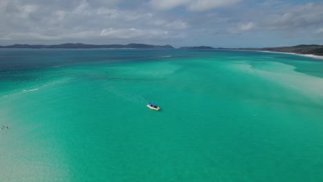 circular-drone-shot-around-a-speed-boat-approaching-Whitehaven-beach-in-the-Whitsundays-in-Queensland,-Australia