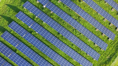 Top-down-aerial-of-rows-of-photovoltaic-solar-panels-on-a-sunny-day