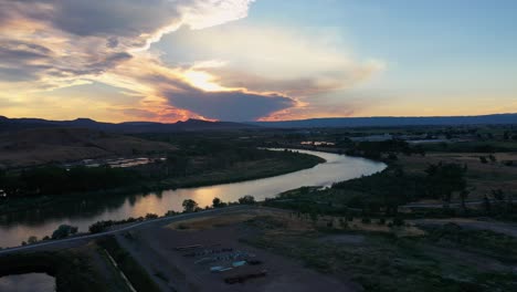 Aerial-view-of-a-cloudy-sunset-above-the-Colorado-river,-colorful-evening-in-USA
