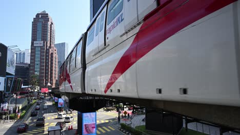 Iconic-and-busy-Bukit-Bintang-district-of-Kuala-Lumpur-with-the-monorail-train-entering-in-the-train-station,-Malaysia