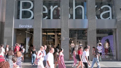 Eine-Große-Gruppe-Von-Fußgängern-Geht-An-Der-Spanischen-Modemarke-Von-Inditex,-Bershka,-Store-In-Spanien,-Vorbei