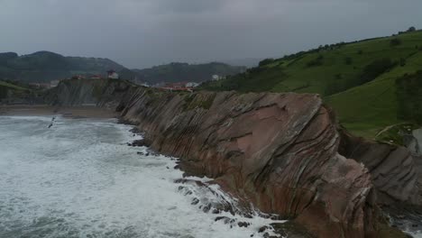 Slow-motino-dolly-in-as-waves-crash-on-angled-sea-cliff-edges-at-itzurun-zumaia-spain