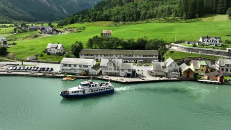 Touristenboot-Verlässt-Im-Sommer-Die-Wunderschöne-Stadt-Fjærland-In-Sogn-Norwegen---Sonniger-Tag,-Luftaufnahme-über-Türkisfarbenem-Gletscherwasser