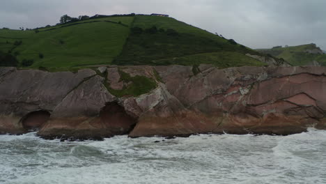 High-angle-trucking-pan-across-flysch-stratigraphic-rock-layers-at-itzurun-zumaia-spain
