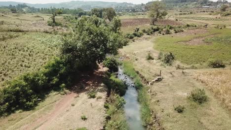 Vista-De-Drones-De-Agricultores-Etíopes-Caminando-A-Lo-Largo-De-Un-Arroyo