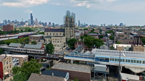 Aerial-view-of-the-pink-line-CTA-train-arriving-at-the-18th-station,-in-Pilsen,-Chicago