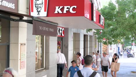 Fußgänger-Gehen-An-Der-Amerikanischen-Fast-Food-Hühnchen-Restaurantkette-Kentucky-Fried-Chicken-Und-Ihrem-Logo-In-Spanien-Vorbei