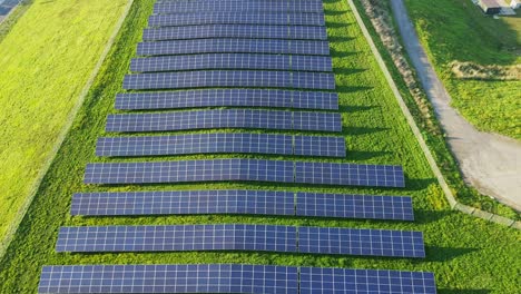 Drohne-Fliegt-über-Reihen-Von-Photovoltaik-Solarpaneelen-Auf-Einem-Grünen-Feld