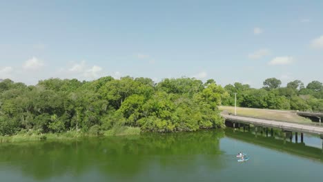 Vista-Aérea-De-Un-Par-De-Kayakistas-Remando-Por-Armand-Bayou-En-El-Parque-Bay-Area-En-Pasadena,-Texas