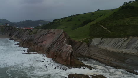 Epic-coastal-sea-cliff-edges-fall-into-ocean-at-itzurun-beach-zumaia-spain