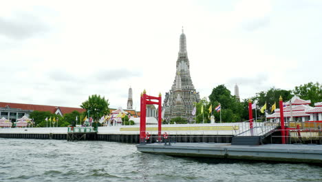 Vista-Del-Río-Chao-Phraya-Con-El-Hermoso-Templo-Wat-Arun-Y-El-Fondo-Del-Cielo-Al-Atardecer,-Wat-Arun-Es-Un-Templo-Budista-Y-Puntos-De-Referencia-En-Bangkok