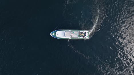 Tourist-sightseeing-boat-top-down-isolated-aerial-view-while-turning-around-before-departure