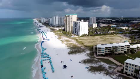 Panning-Aerial-view-of-resort-or-hotels-on-the-Henderson-Beach-state-park,-Destin,-Florida,-United-States,-and-coastline-with-colorful-cloud-and-blue-sky,-Gulf-of-mexico