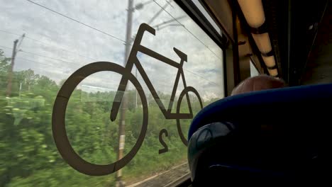 Im-Zug-Schaue-Ich-Aus-Dem-Fenster-Mit-Aufgedrucktem-Fahrradlogo,-Während-Ich-Durch-Frankreich-Reise