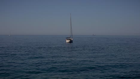 Vista-Serena-De-Un-Pequeño-Barco-De-Pesca-Y-El-Movimiento-De-Las-Suaves-Olas-En-La-Playa-De-Camogli,-Italia