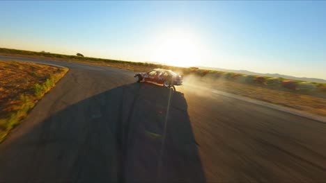 Epic-FPV-aerial-drone-following-a-race-car-speeding-and-drifting-down-a-track-at-sunset