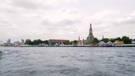 Vista-Del-Río-Chao-Phraya-Con-El-Hermoso-Templo-Wat-Arun-Y-El-Fondo-Del-Cielo-Al-Atardecer,-Wat-Arun-Es-Un-Templo-Budista-Y-Puntos-De-Referencia-En-Bangkok