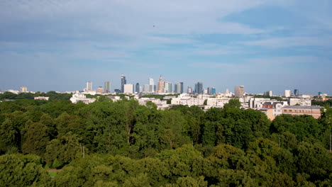 Panoramic-drone-view-over-green-park-and-boulevard-of-Warsaw-skyline