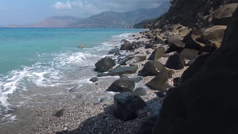 Splashing-sea-waves-on-beautiful-rocks-plunged-on-beach-of-Mediterranean-coastline-in-Albania,-wild-shore