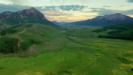 Aerial-of-the-town-of-Crested-Butte,-at-left,-and-it's-lush-green-valley-and-mountains,-Colorado,-USA