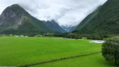 Luftaufnahmen-Zwischen-Flaggen-Auf-Dem-Dach-Des-Fjaerland-Gletschermuseums-Mit-Boyabreen-Gletscher-Im-Hintergrundtal-–-Norwegen-Sogn-60-Fps