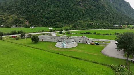 Fjaerland-Gletschermuseum-Und-Ausstellung-In-Sogn-–-Orbit-Luftaufnahme-Um-Ein-Preisgekröntes-Designgebäude-Mit-Darauf-Stehenden-Touristen-Im-Sommer-In-Norwegen-–-60-Fps
