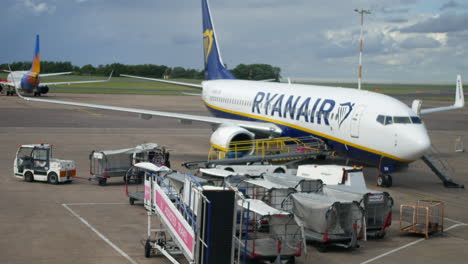 Verladen-Von-Gepäck-In-Ein-Ryanair-Flugzeug-Auf-Der-Landebahn-Mit-Gepäckabfertigern-Und-Flugzeugen-Am-Flughafen