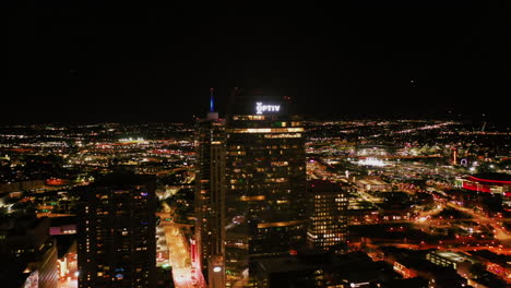 Aerial-tracking-shot-of-the-illuminated-cityscape-in-Denver,-night-in-Colorado,-USA
