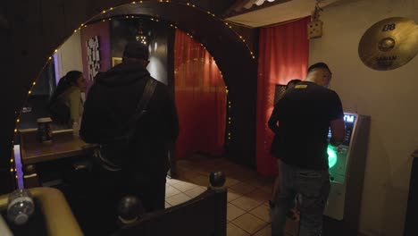 Türsteher-Nimmt-Bezahlung-Im-Salsa-Nachtclub-El-Rancho-Entgegen-Und-Mann-Benutzt-Geldautomaten