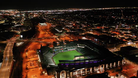 Aerial-view-tilting-toward-the-Coors-Field-stadium,-nighttime-in-Denver,-Colorado