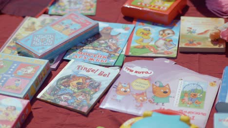 Libros-Y-Juegos-Para-Niños-Expuestos-En-El-Suelo-En-Un-Mercado-De-Pulgas