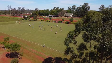 Cinematic-video-revealing-soccer-players-on-green-field-with-referee-on-the-side