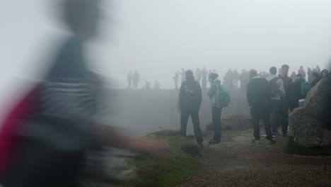 Vista-De-La-Roca-Del-Púlpito,-Preikestolen-En-Noruega,-Muchos-Turistas-Tomando-Fotografías-En-Un-Día-Nublado-Y-Brumoso,-Turismo-Masivo-Con-Mal-Tiempo,-Efecto-De-Obturación-Lenta