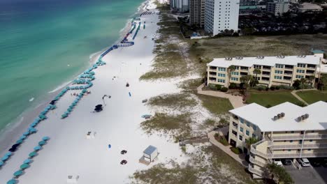 Vista-Aérea-De-Silver-Dunes-Condominiums-Beachfront-Resort,-Destin,-Florida,-Estados-Unidos-Y-Costa-Con-Coloridas-Sillas-De-Playa,-Sombrillas,-Nubes-Cielo-Azul,-Vista-Aérea-Del-Parque-Estatal-Henderson-Beach