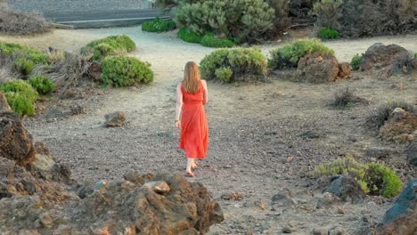 Frau-Im-Orangefarbenen-Kleid-Erkundet-Die-Vulkanlandschaft-Des-Teide-Nationalparks