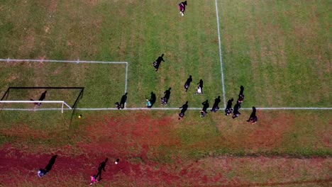 Eagle-eye-POV-of-soccer-players-on-green-field,-warm-up-break