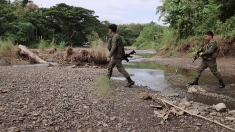 Tropas-Asiáticas-Cruzando-Selva-Arroyo-Guerra-Armas-Pistola-Riffel-Ak-47