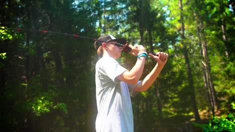 Young-angler-enjoys-fishing-on-a-pond-in-the-woods